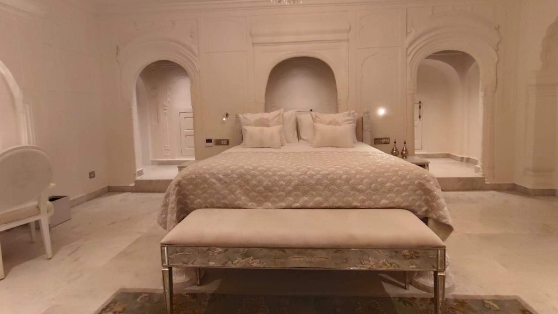 Bed bench beside a white king bed in the Deluxe Suite at Raan Bass The Palace