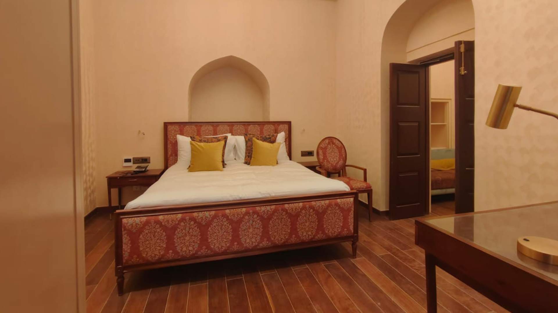 Red-themed king-size bed in the Junior Suite at Raan Bass The Palace