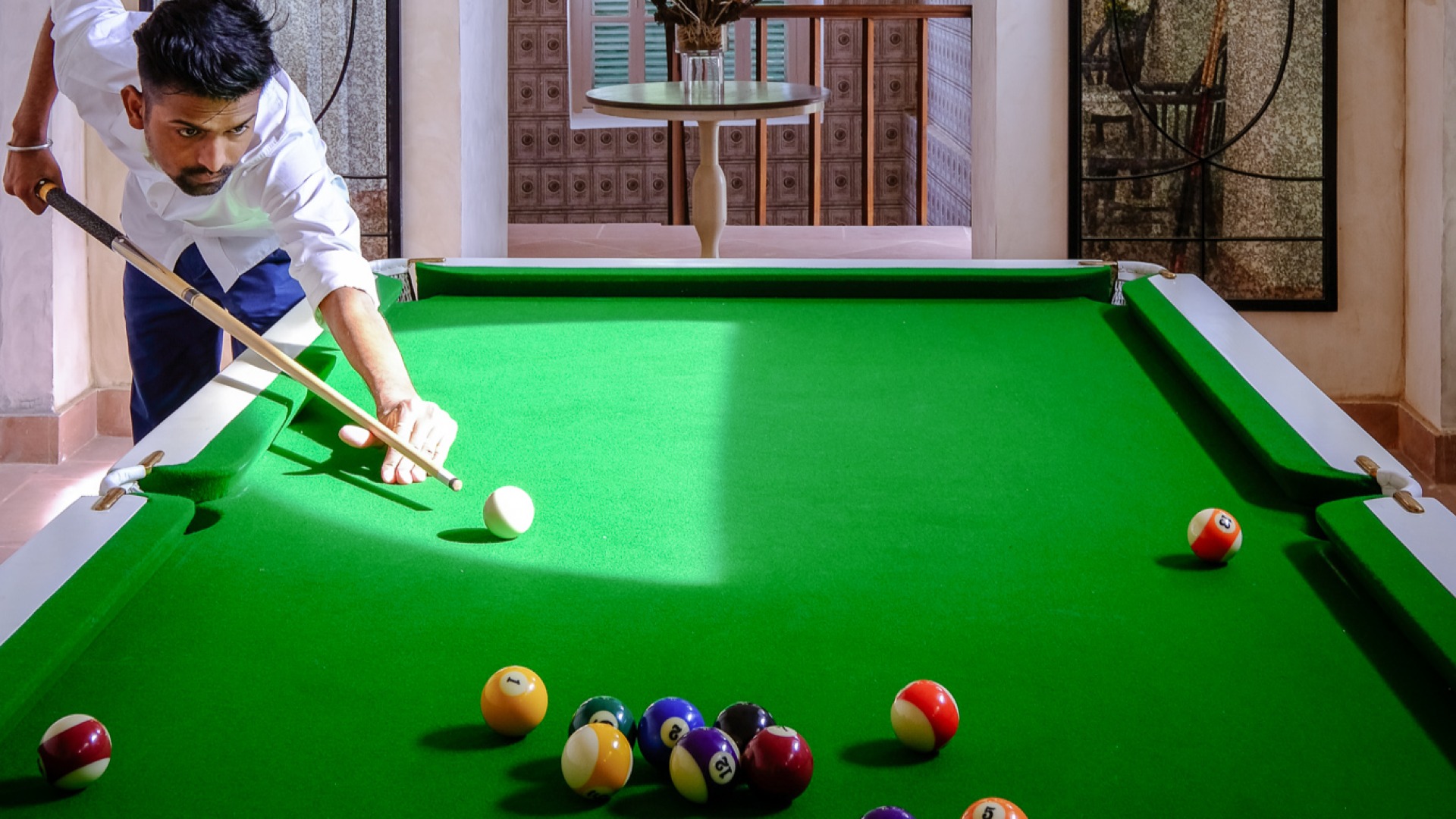 A young man playing billiards at The Denmark Tavern